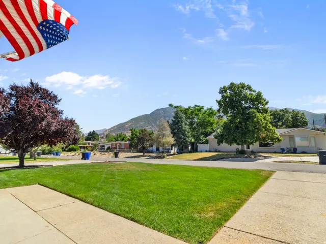 Expansive green lawn with a sidewalk and mountain backdrop