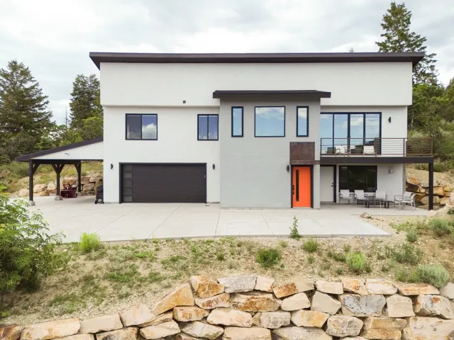 Contemporary architecture with a vibrant orange entry door and black-framed windows
