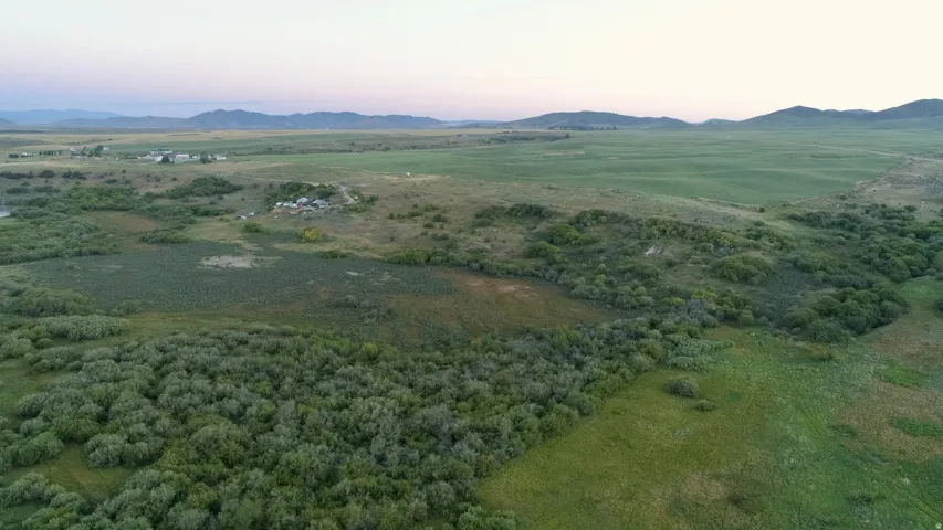 Expansive agricultural land featuring a diverse landscape of fields and natural vegetation