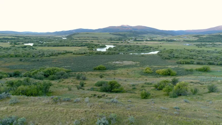 Expansive natural landscape featuring rolling hills and distant mountains