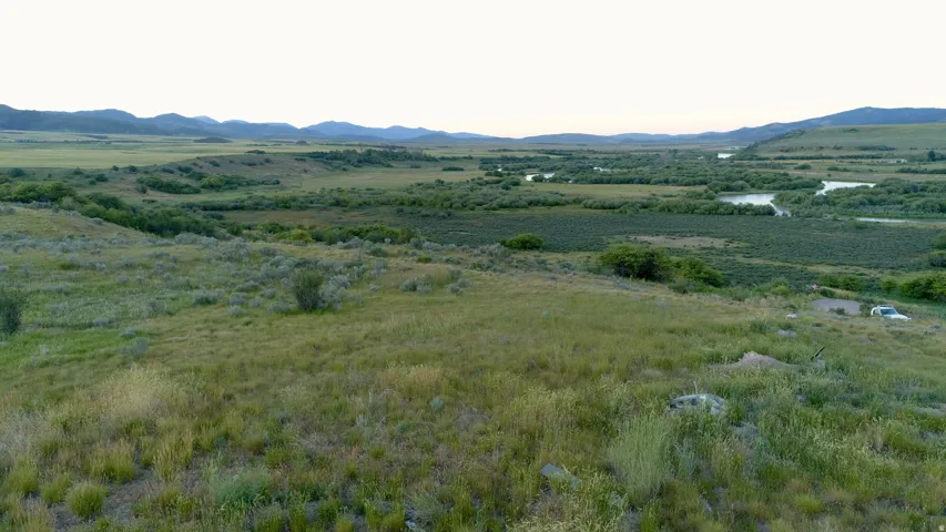 Expansive natural landscape featuring rolling hills and distant mountains