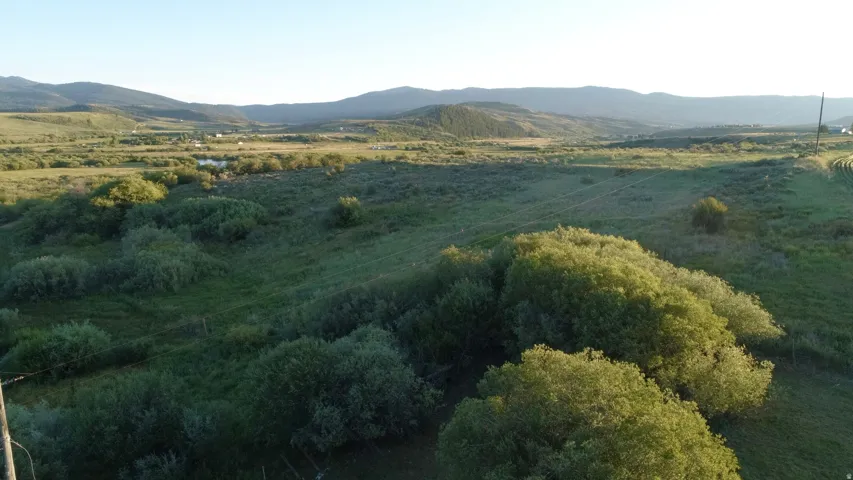 Expansive natural landscape featuring rolling hills and distant mountains