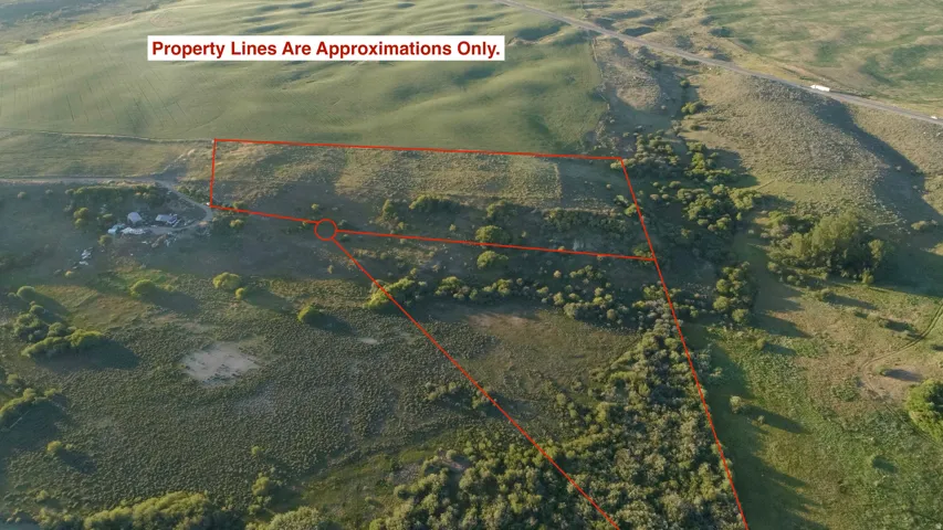 Expansive land parcel featuring varied topography, including rolling hills and flat areas