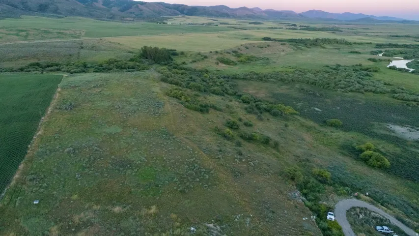 Expansive green landscape featuring varied terrain, cultivated fields, and natural waterways