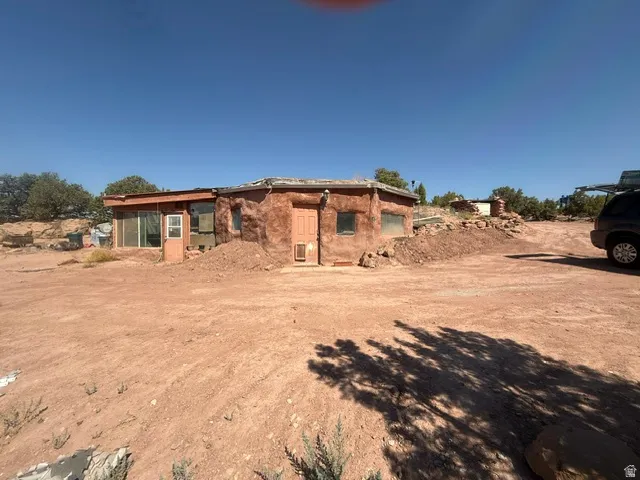 Adobe-style exterior featuring a natural earth tone finish and a flat roofline