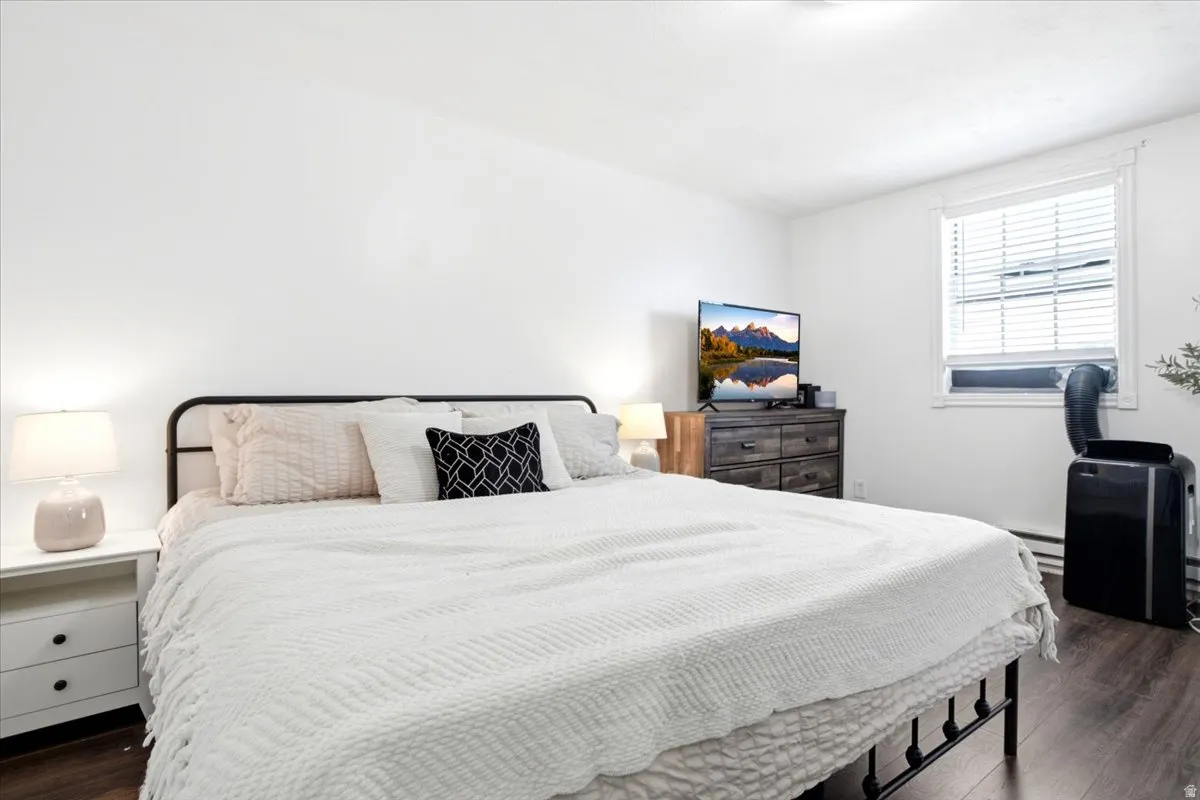 Bedroom featuring dark wood-finish flooring and white walls