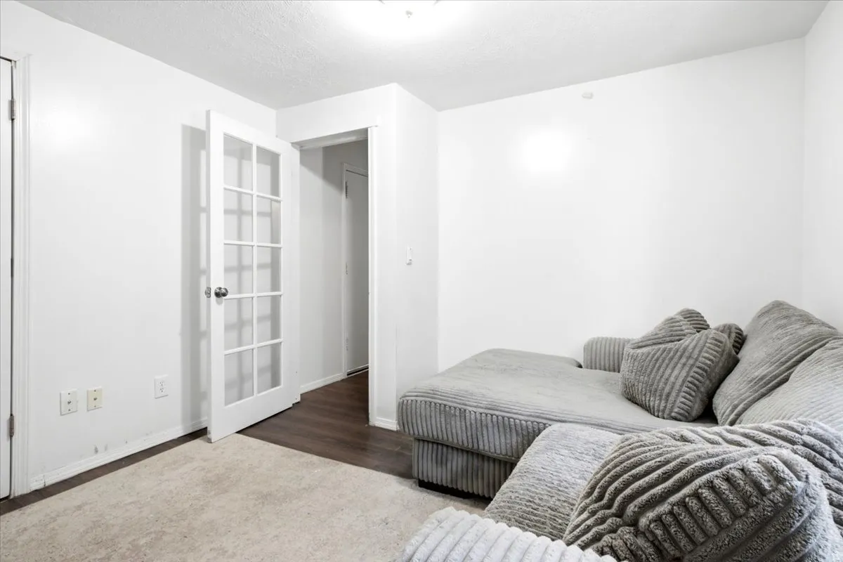 Interior space featuring white walls and a white paneled door with glass inserts