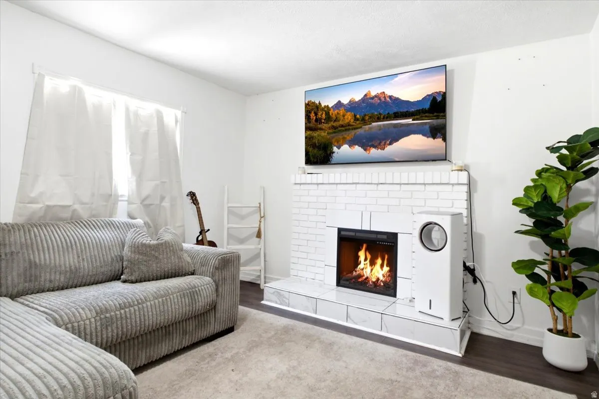 Living room featuring a white brick fireplace with a firebox and hearth