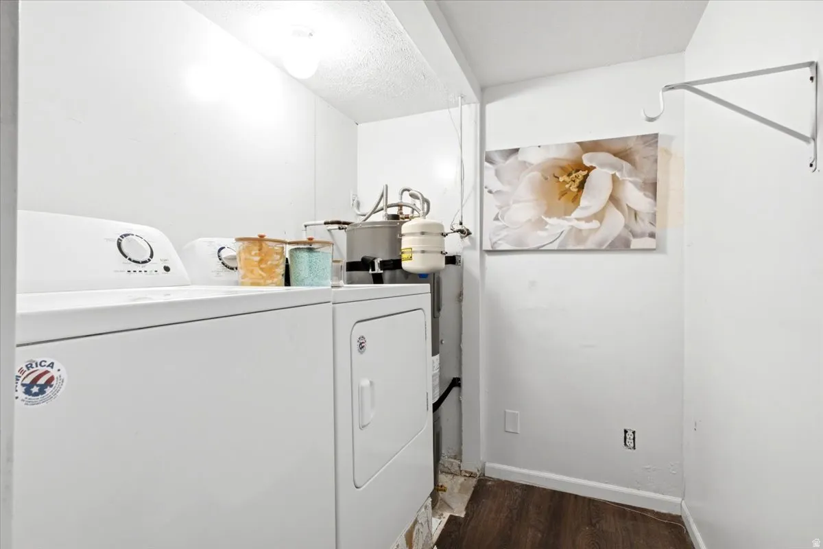 Utility area featuring wood-finish flooring, white walls, and a wall-mounted bracket