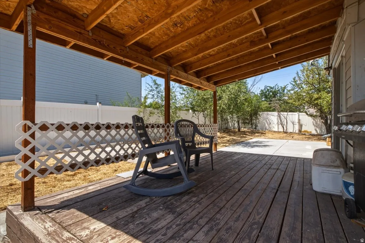 Covered wooden deck with a slatted wood ceiling, supported by wood posts