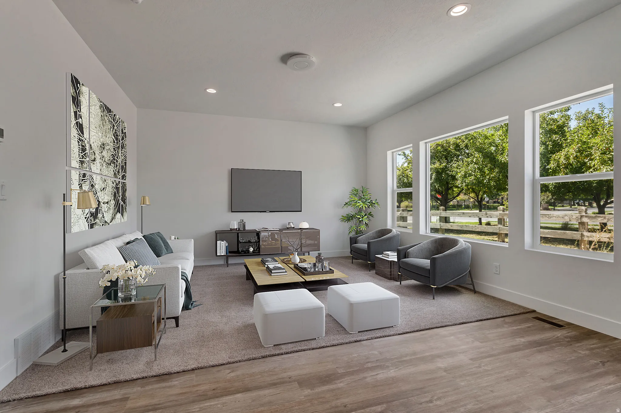 Spacious living area featuring large windows, wood-finish flooring, recessed lighting, and a neutral color palette