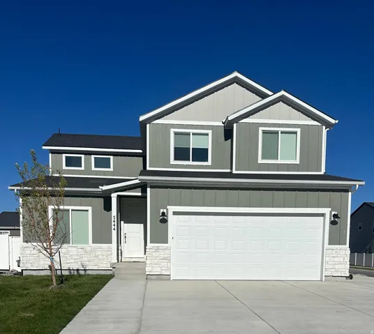 Contemporary two-story residence featuring a two-car garage, board and batten siding, and stone accents