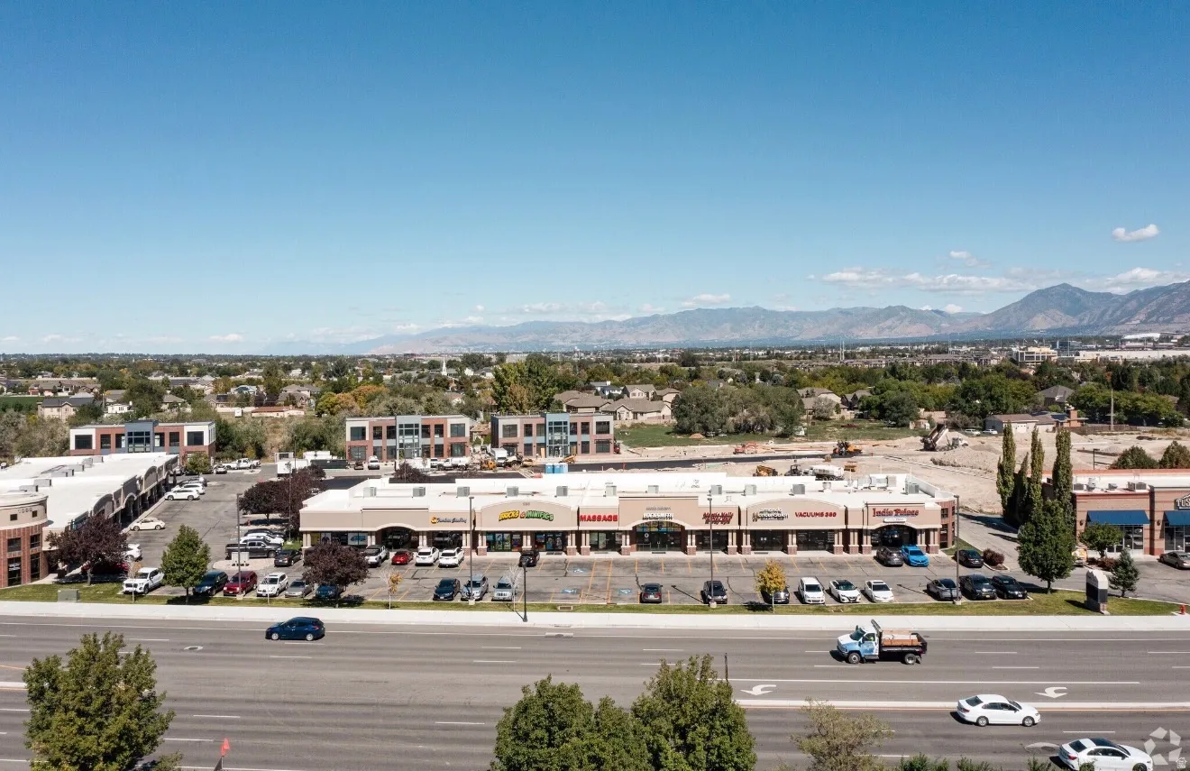 Commercial strip mall with multiple retail spaces and ample front-facing parking