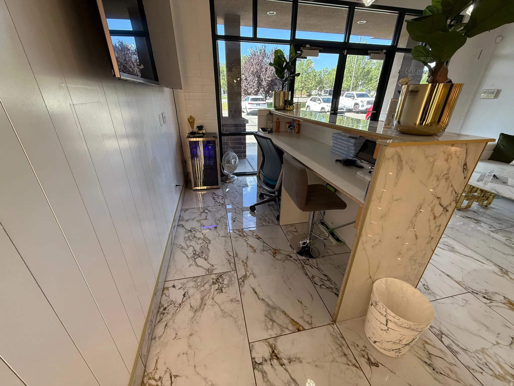 Reception area featuring a marble-finish counter, large format marble-finish floor tiles, and a shiplap accent wall