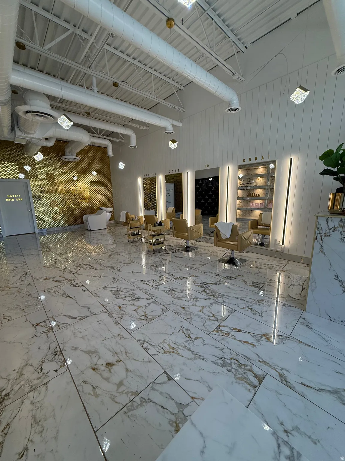 Expansive white and gold marble-patterned tile flooring provides a luxurious foundation