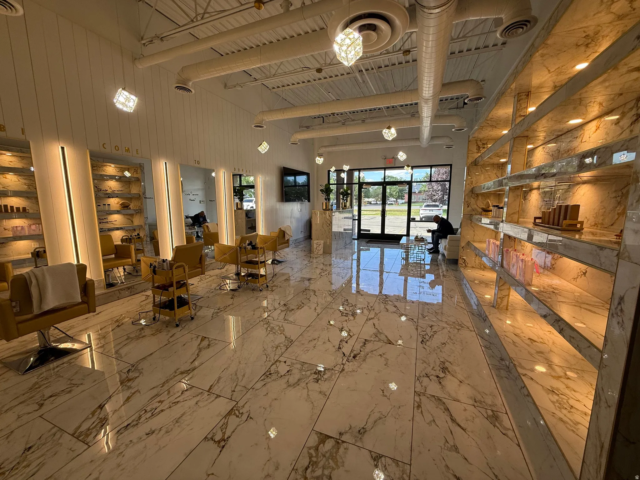 Spacious commercial interior featuring large-format marble-look floor tiles and a high exposed ceiling with visible ductwork