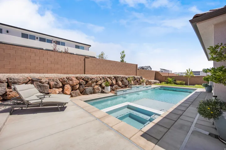 Contemporary backyard featuring a rectangular swimming pool with integrated spa and light-colored coping