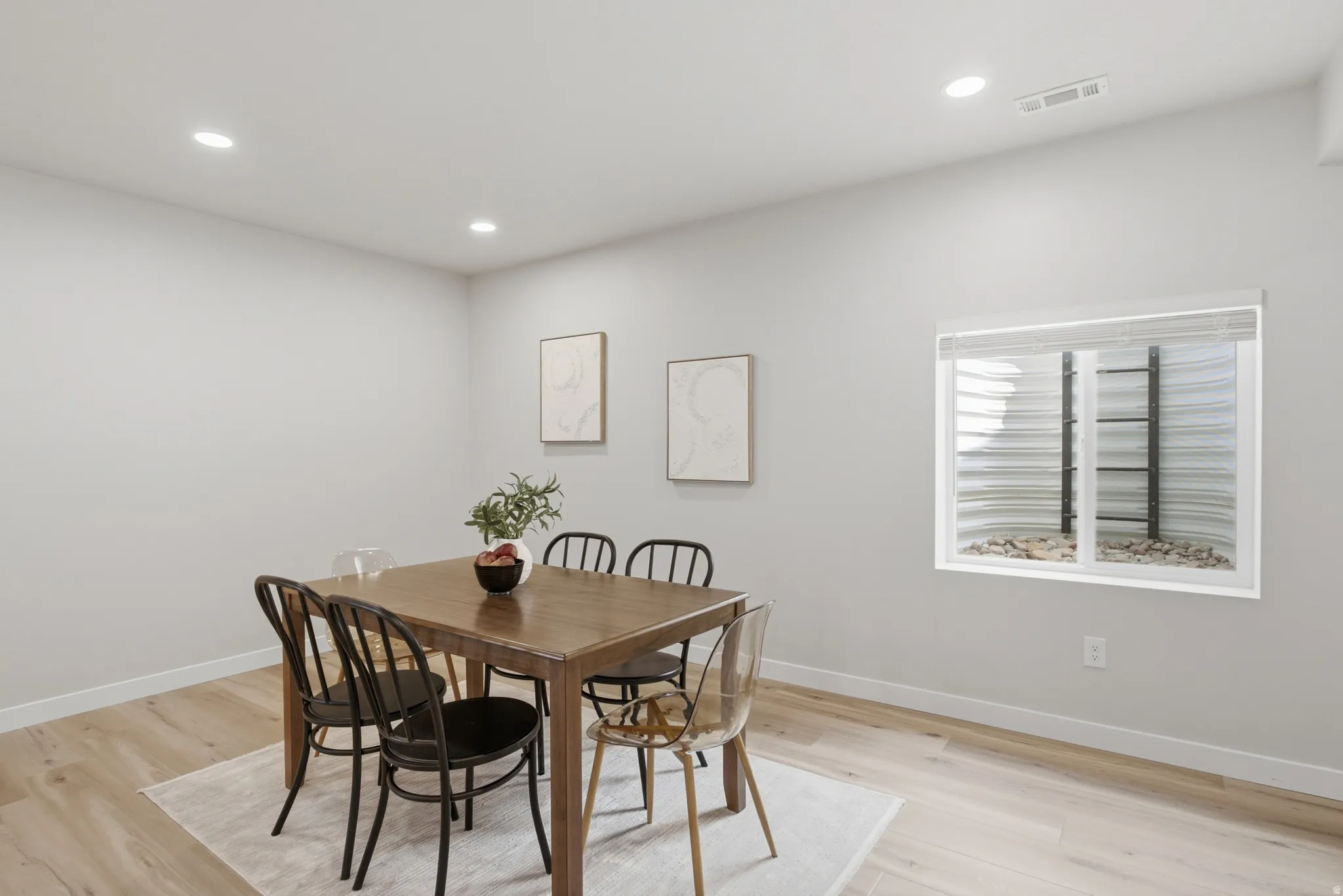 Versatile space featuring light wood-finish flooring, recessed lighting, and a window with blinds
