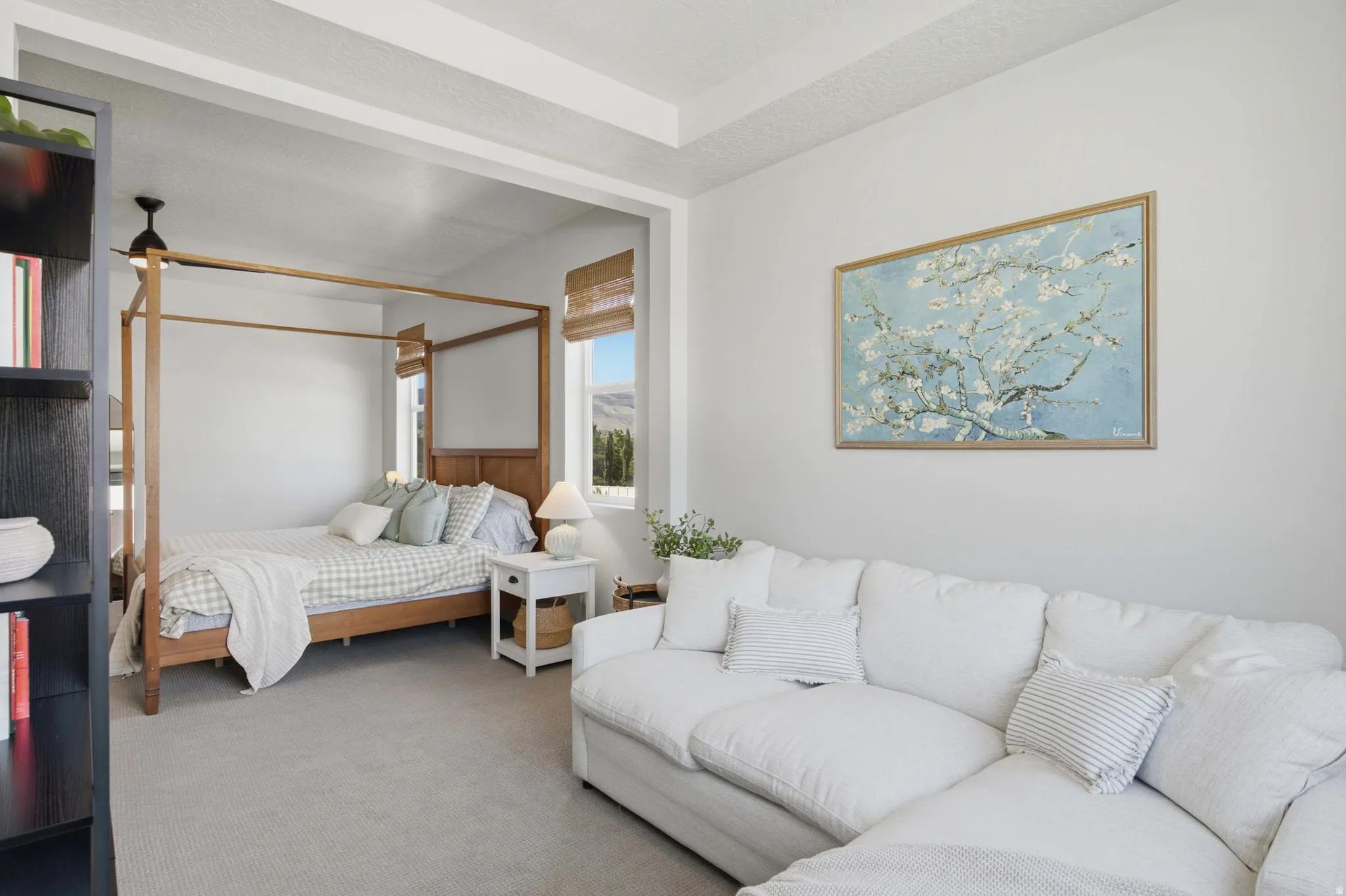 Primary Bedroom featuring light-colored carpeting and a tray ceiling