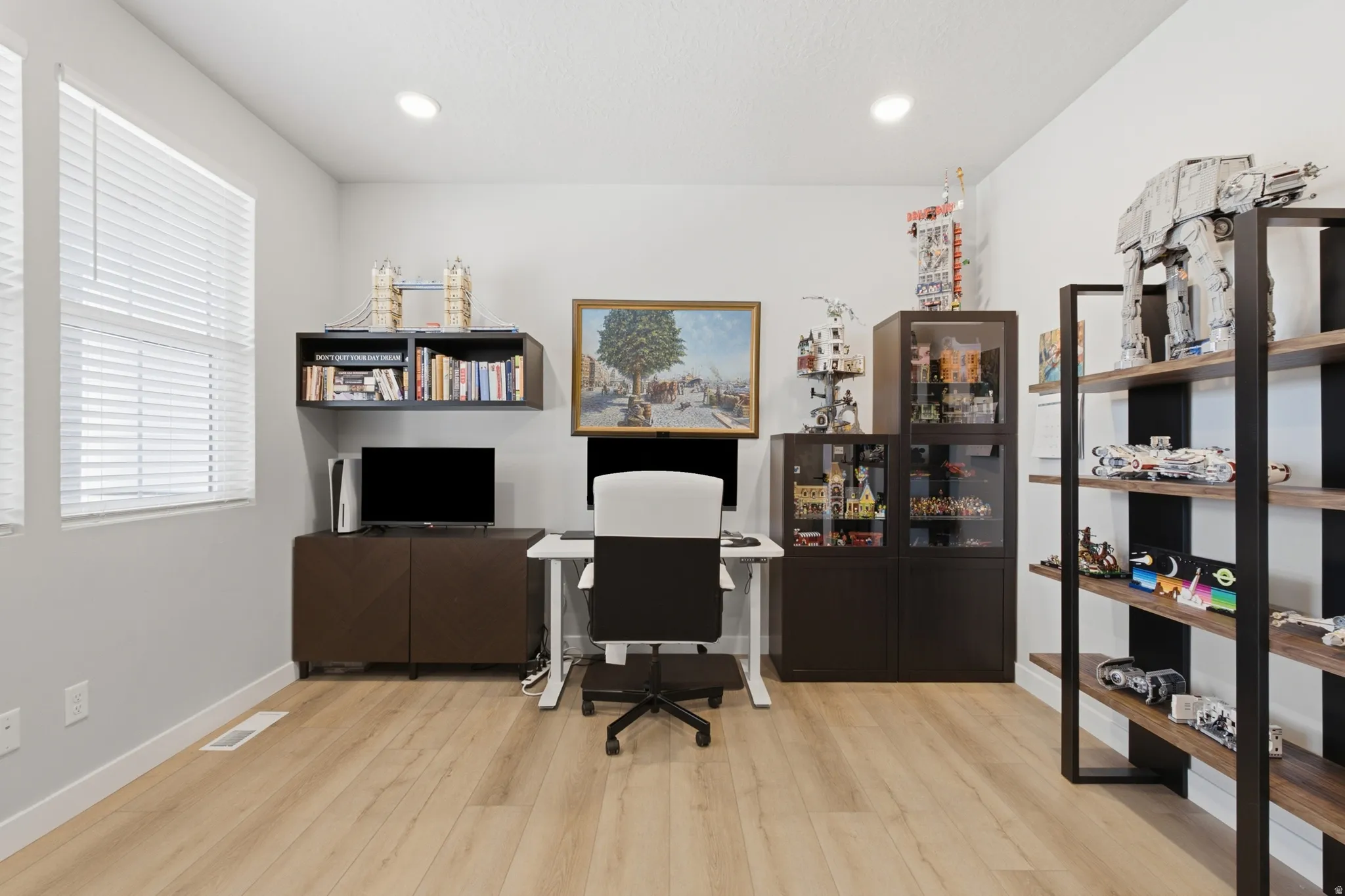 Bright room featuring light wood-finish flooring, white walls, and recessed lighting