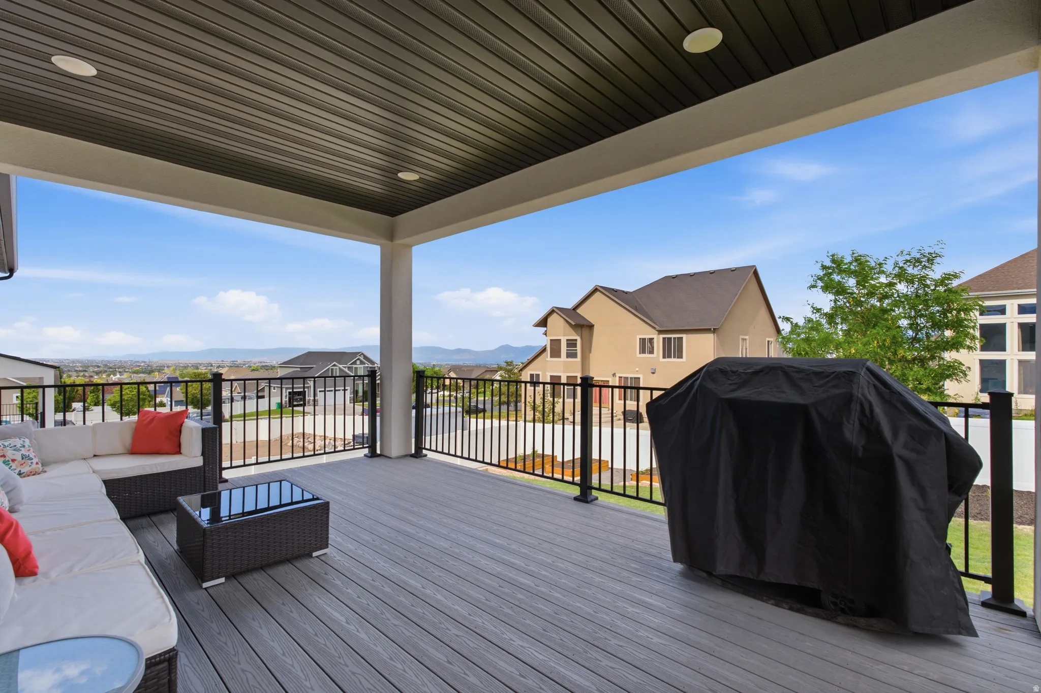 Large covered outdoor deck with wood-finish flooring