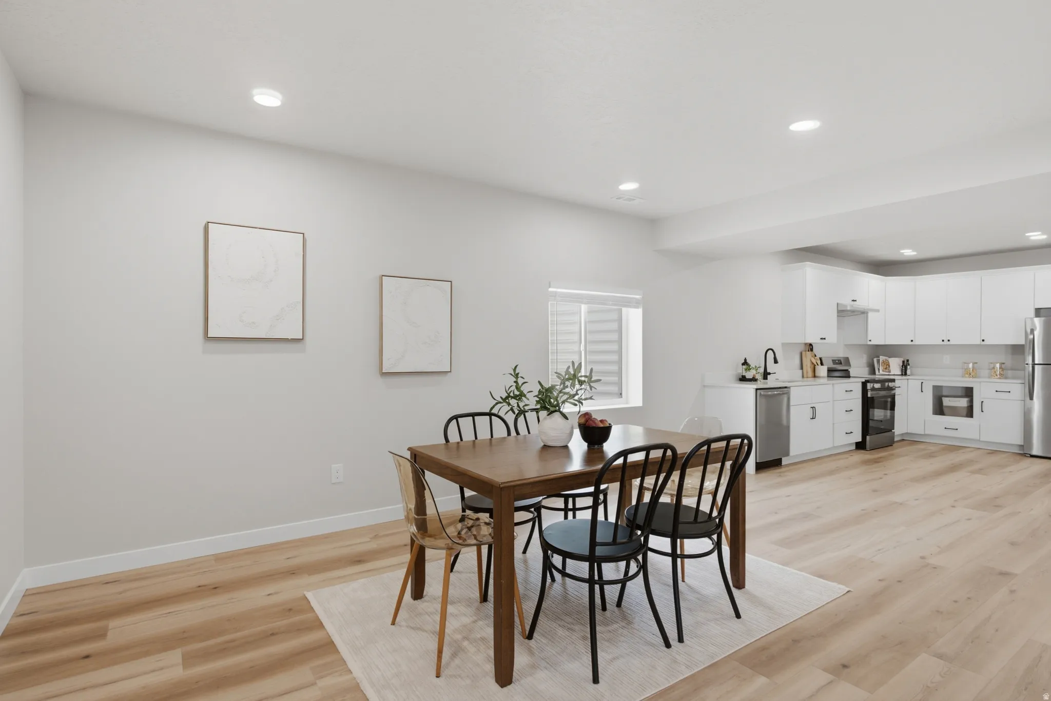 Open-concept living space featuring wood-finish flooring, recessed lighting, and a modern kitchen