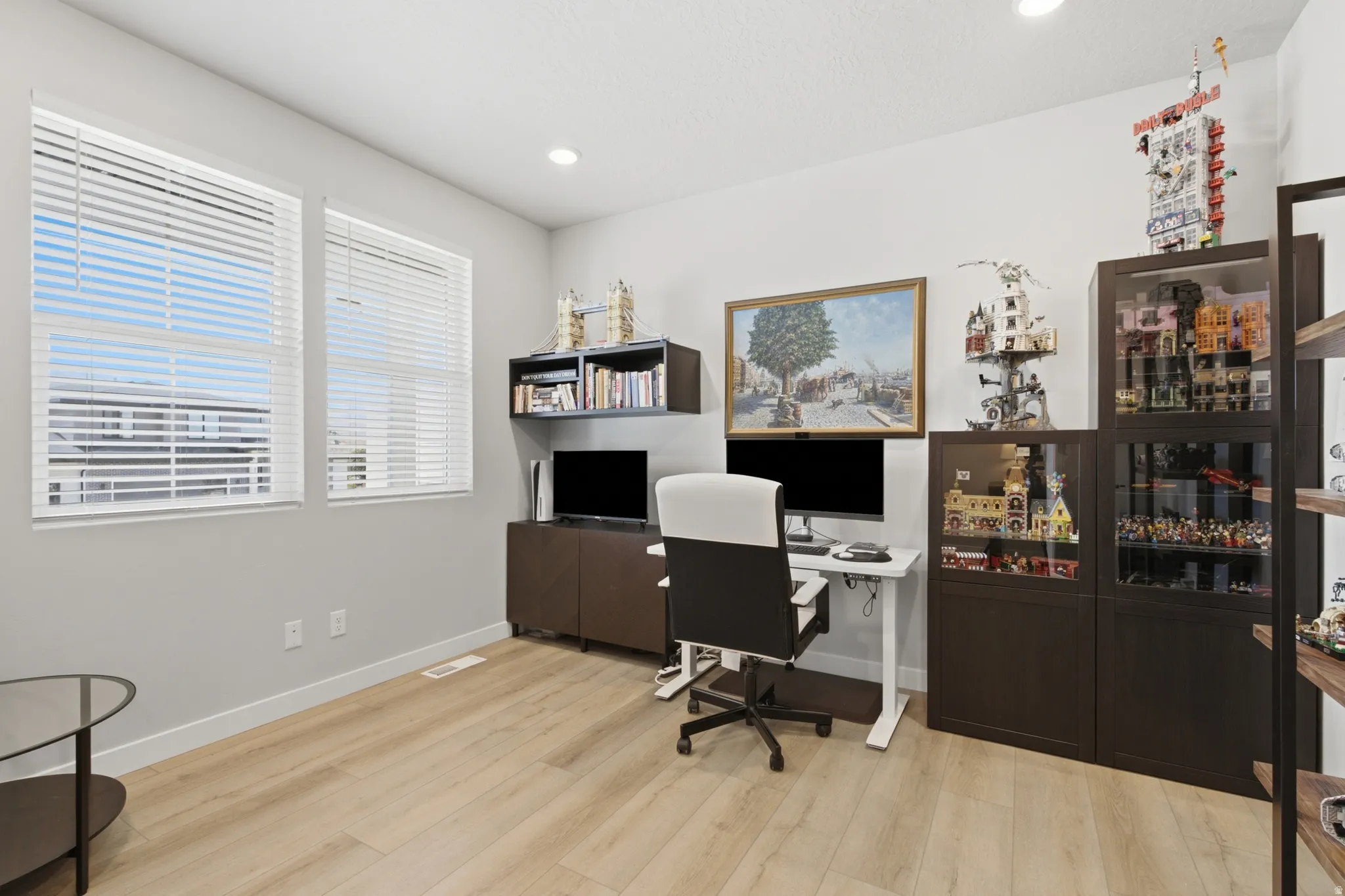 Bright room featuring two large windows with white blinds, light wood-finish flooring, recessed lighting, and ample wall space