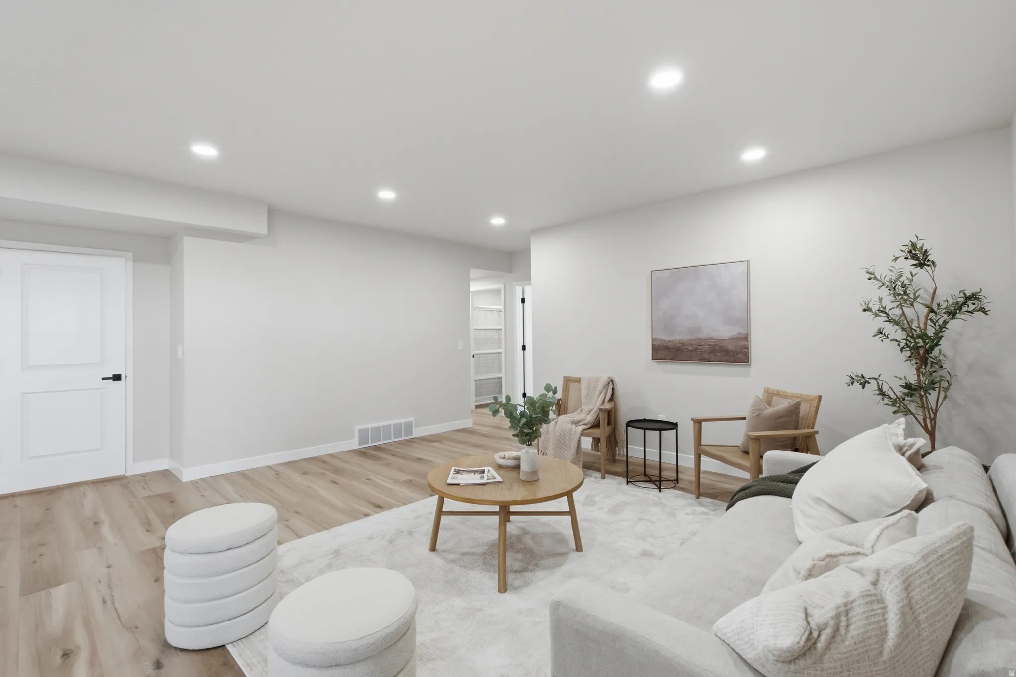 Spacious room with recessed lighting, light wood-finish flooring, and white baseboards