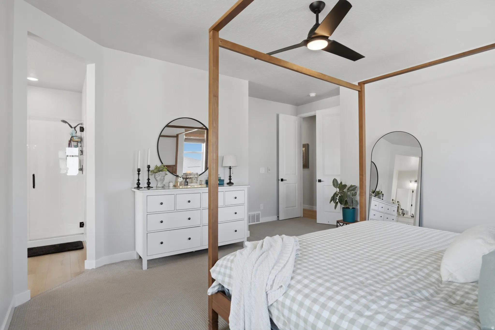 Spacious bedroom featuring light neutral walls and light-colored carpeting