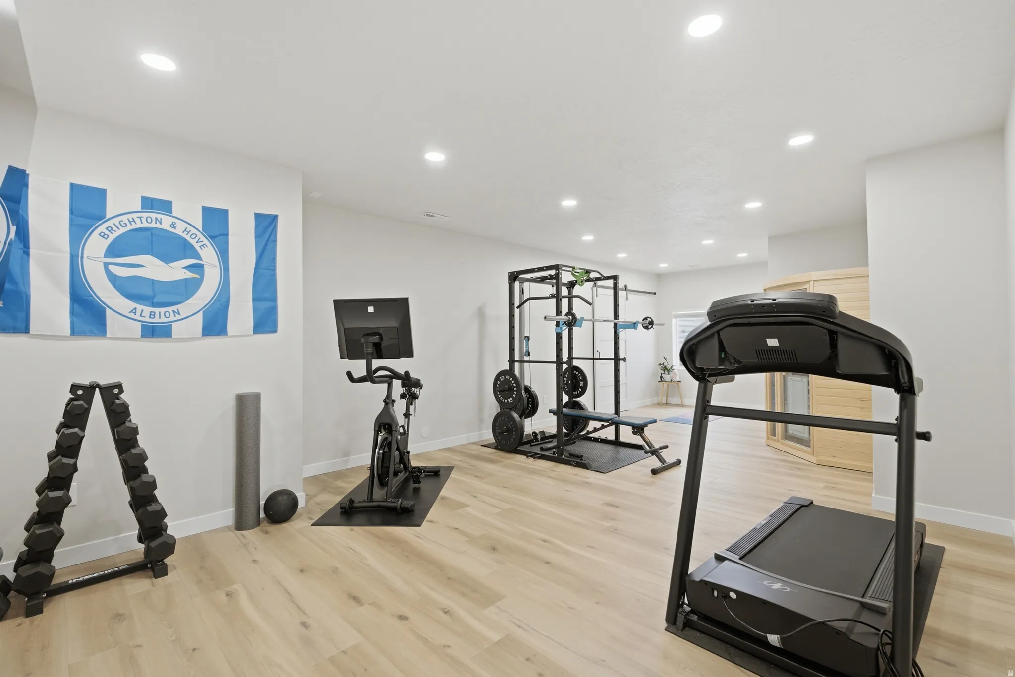 Dedicated fitness room featuring recessed lighting, light wood-finish flooring, and white walls