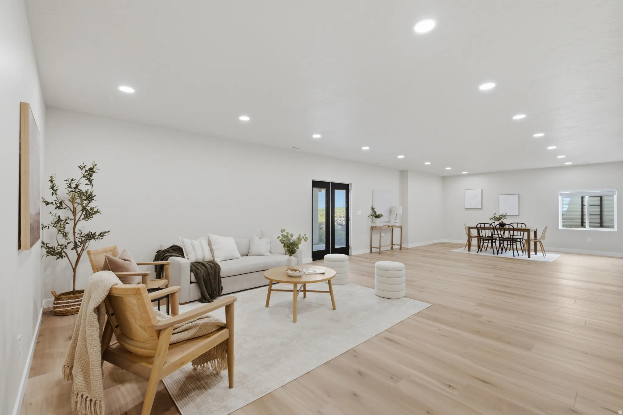 Spacious open-concept room featuring 10' ceilings, light wood-finish flooring and recessed lighting throughout