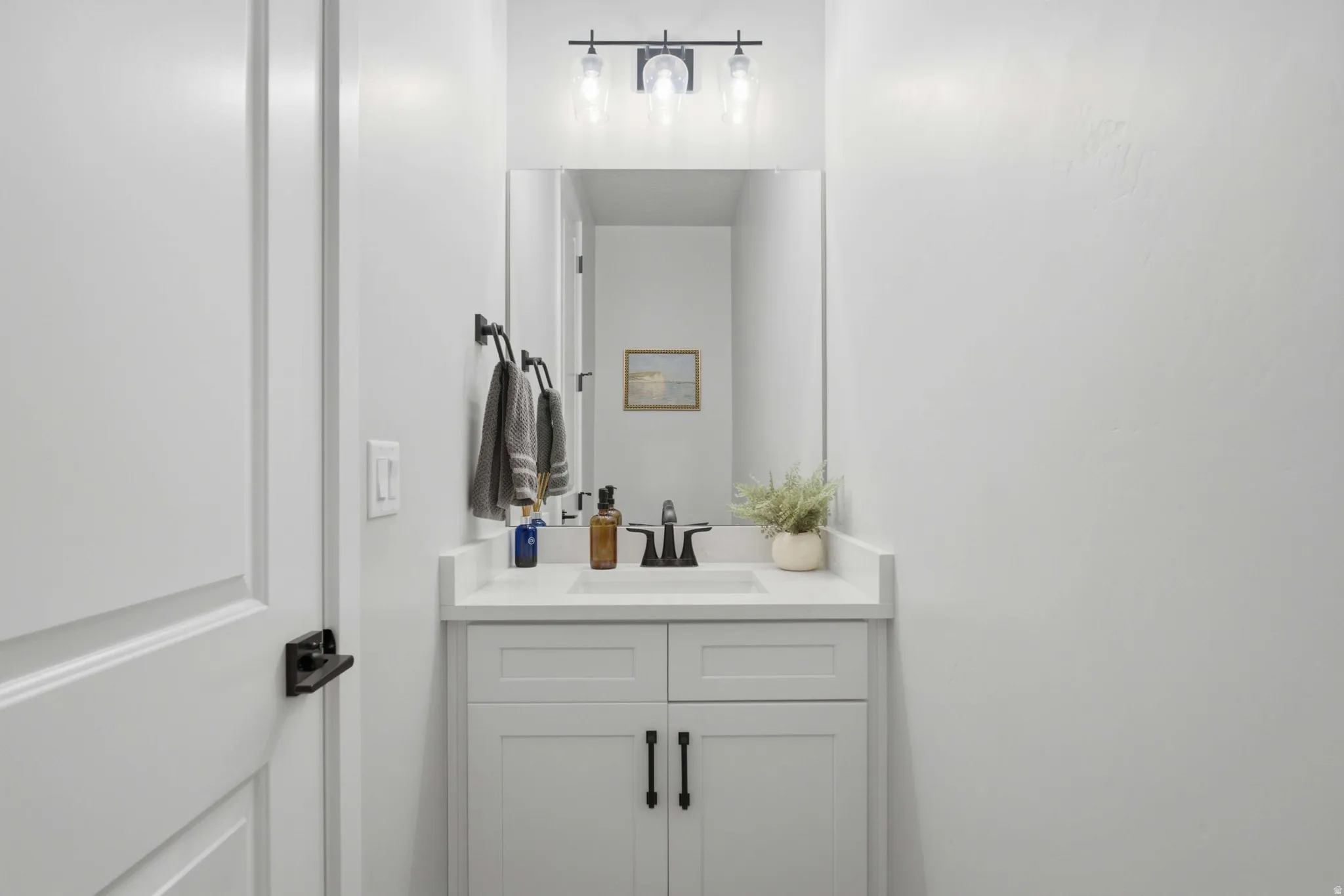 Guest Bathroom with white vanity with shaker-style cabinetry, a built-in sink, and a white countertop