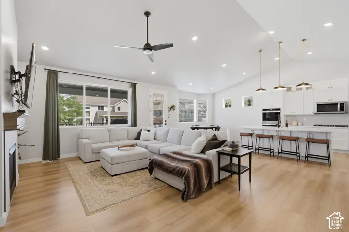 Open-concept living area featuring a vaulted ceiling and wood-finish flooring