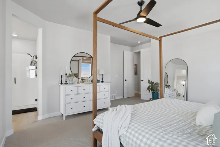 Spacious bedroom featuring light neutral walls and light-colored carpeting