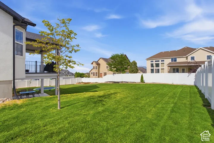 Expansive green lawn framed by a white privacy fence