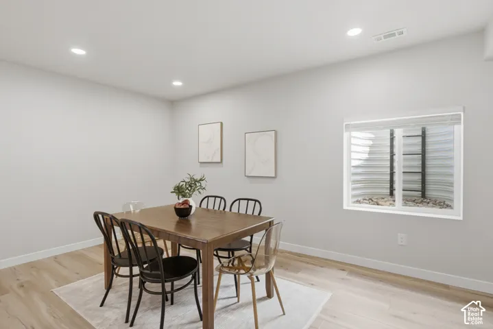 Versatile space featuring light wood-finish flooring, recessed lighting, and a window with blinds