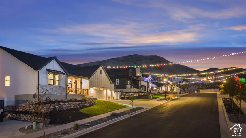 Modern farmhouse architecture with a covered front porch, attached garage, and landscaped rock garden