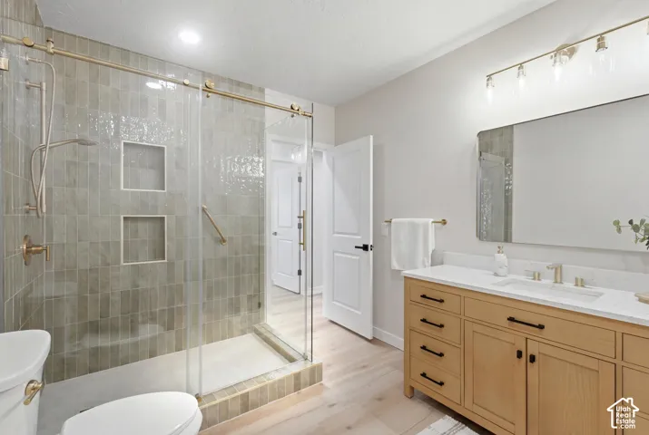 ADU Contemporary bathroom featuring a spacious glass-enclosed shower with custom vertical tile, dual shower niches, and gold-tone fixtures