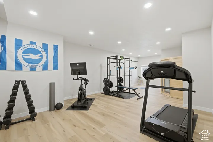 Dedicated fitness room featuring recessed lighting, light wood-finish flooring, and white walls