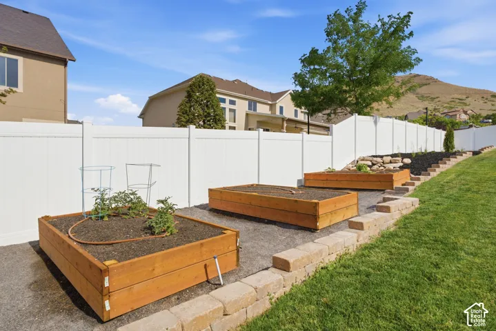 Tiered backyard landscaping featuring three raised garden beds with irrigation