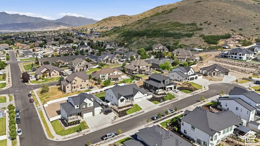 Expansive residential community featuring a variety of architectural styles, paved streets, and mountainous surroundings