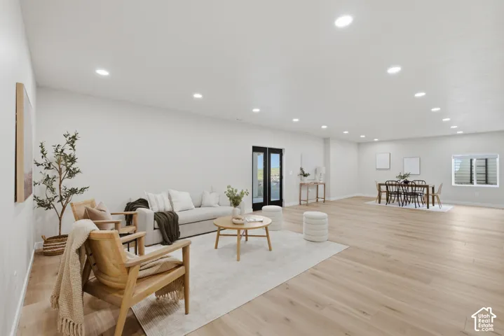 Spacious open-concept room featuring 10' ceilings, light wood-finish flooring and recessed lighting throughout
