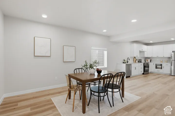 Open-concept living space featuring wood-finish flooring, recessed lighting, and a modern kitchen