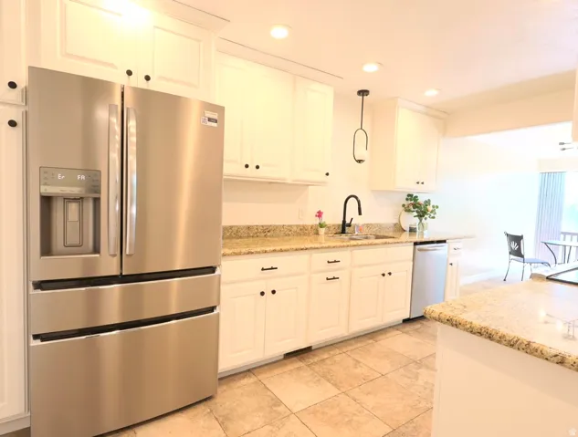 Kitchen with white shaker-style cabinetry, granite countertops, stainless steel appliances, and tiled flooring