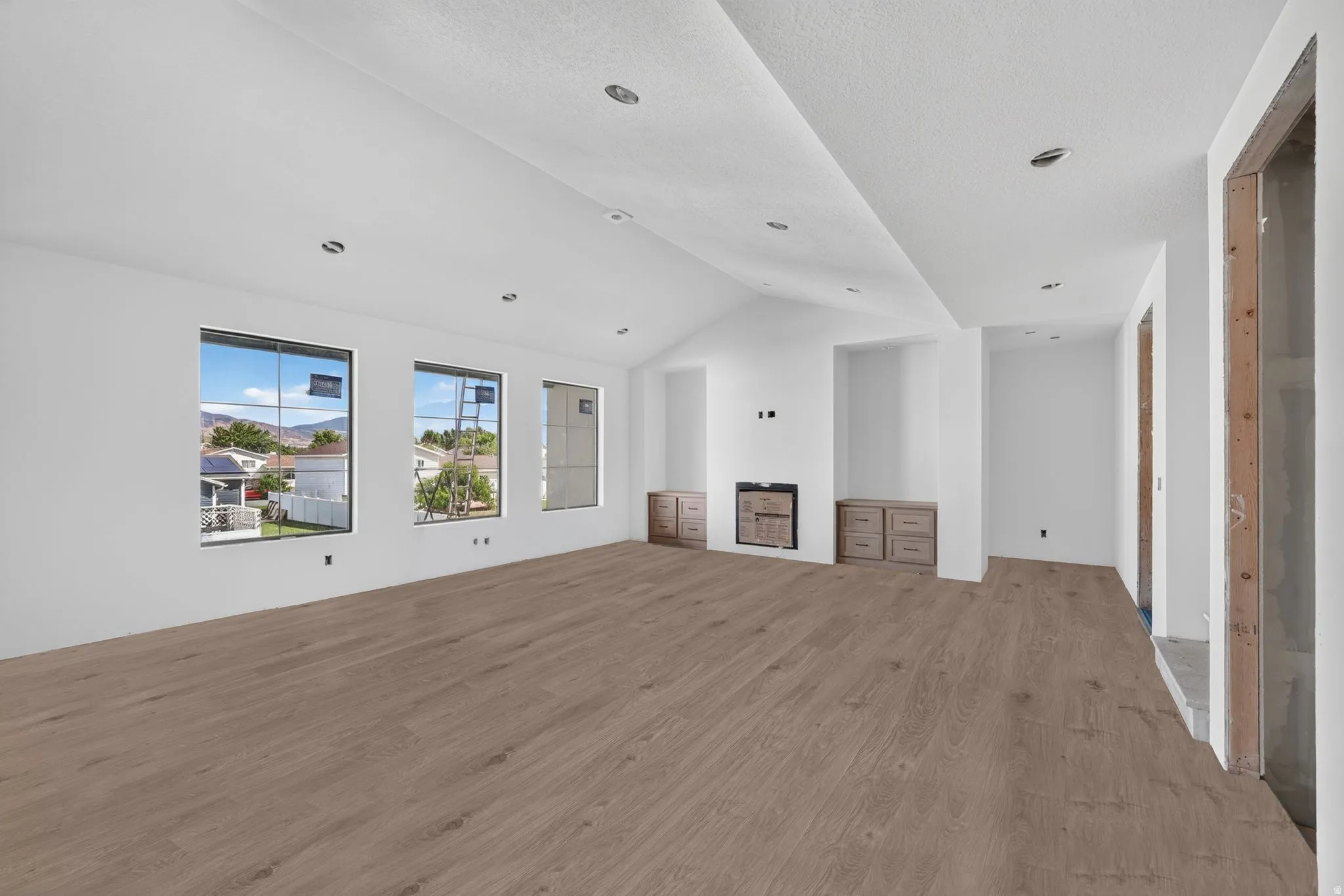 Spacious interior with wood-finish flooring, recessed lighting, and multiple windows