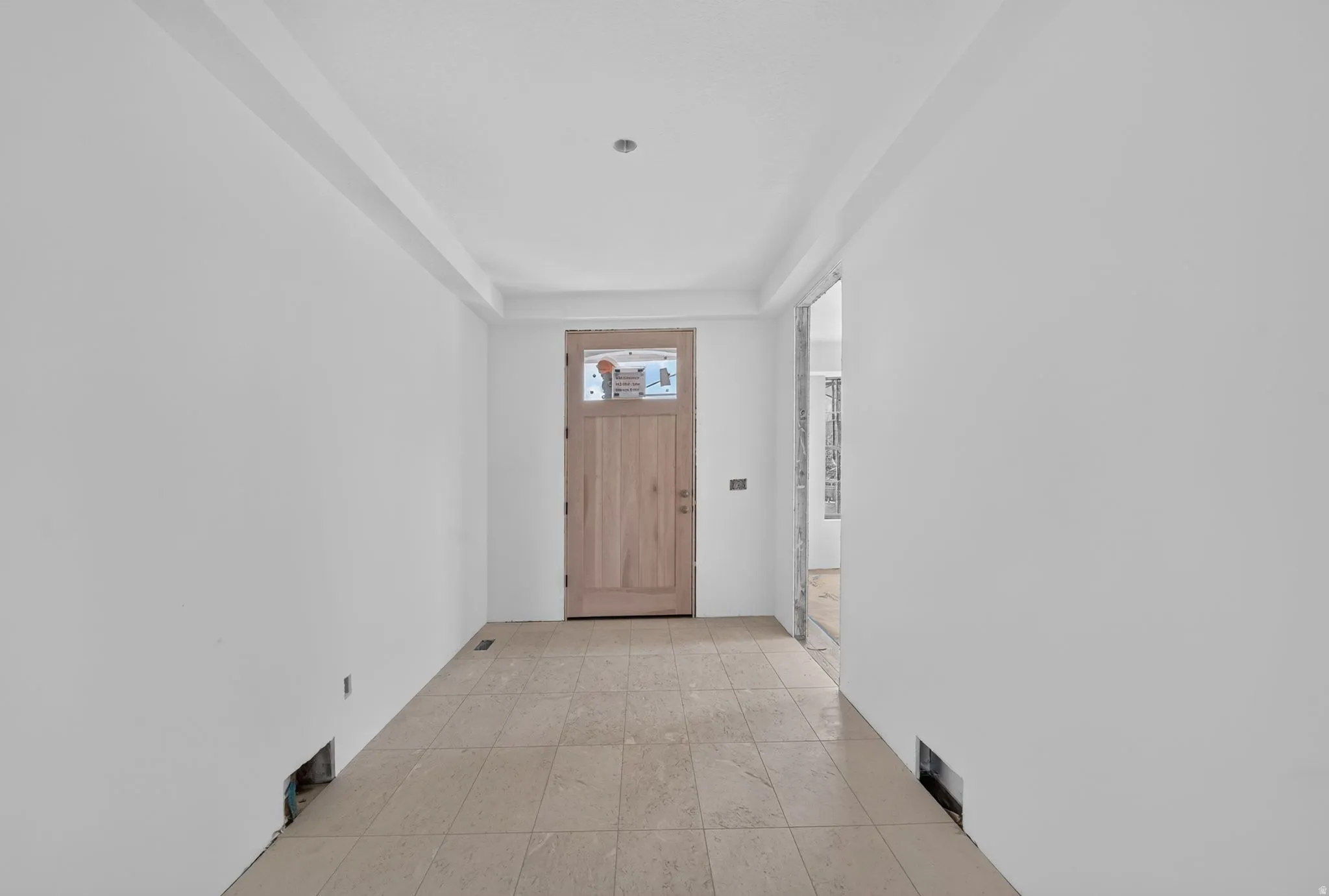 Welcoming entryway featuring neutral wall finishes, recessed ceiling lighting, and tile flooring throughout