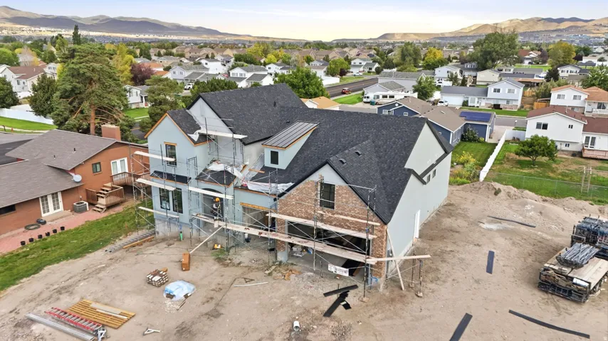 New construction featuring a dark shingle roof, brick and siding exterior, and multiple windows