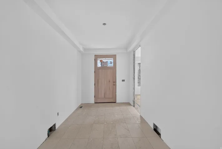 Welcoming entryway featuring neutral wall finishes, recessed ceiling lighting, and tile flooring throughout