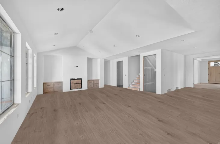 Expansive open floor plan with soaring vaulted ceilings and recessed lighting throughout