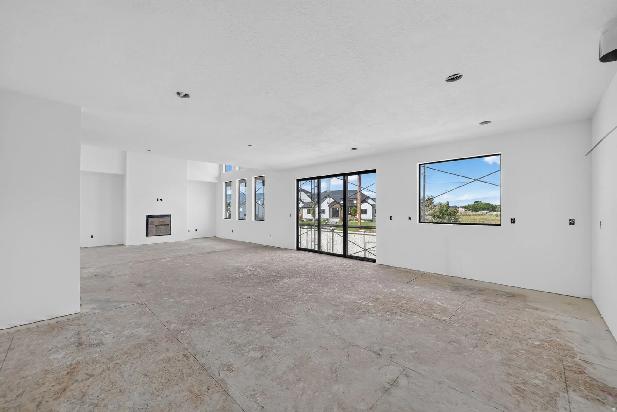 Spacious interior featuring a built-in fireplace, multiple large windows, and sliding glass doors